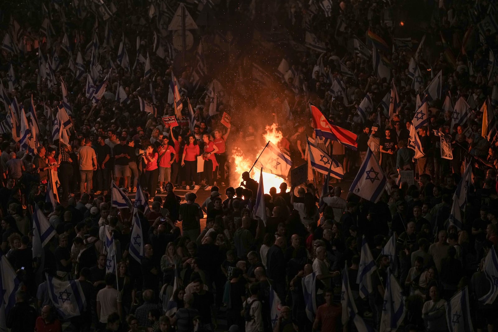 Israelis light a bonfire during a protest after Prime Minister Benjamin Netanyahu has dismissed his popular defense minister Yoav Gallant, in Tel Aviv, Israel, Tuesday, Nov. 5, 2024. (AP Photo/Oded Balilty)