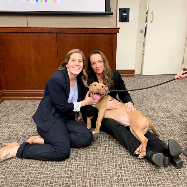 Prosecutors K.C. Pagnotta (left) and Jessica Rock are shown with Baby Shark, one of the dogs recovered at a dogfighting operation in Paulding County. A Georgia man who the authorities said kept more than 100 dogs in cruel conditions at his home was sentenced to 475 years in prison after being found guilty last month of dogfighting and cruelty to animals, prosecutors said. (Courtesy of Paulding District Attorney's Office)