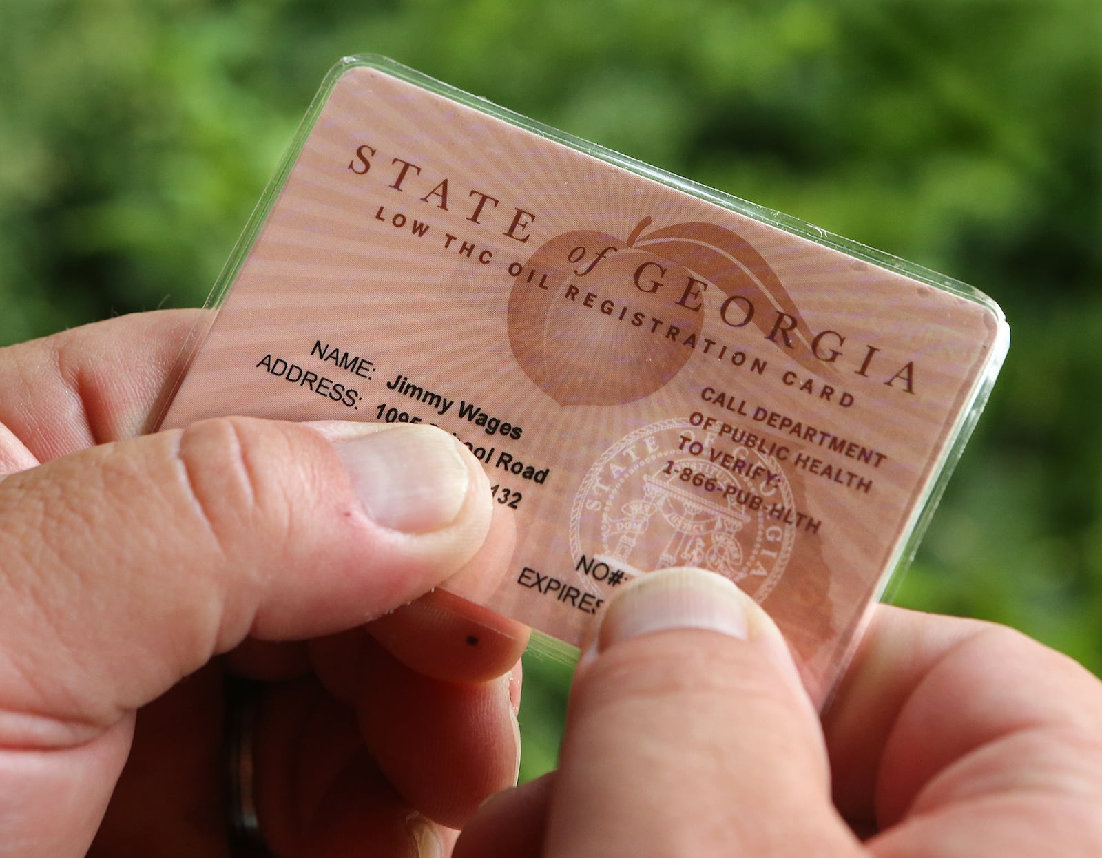 After battling for years to help treat his daughter, Sydney, who suffers from intractable seizures and uses cannabis oil as a treatment, J-Bo Wages finally holds his State of Georgia low THC oil registration card on Tuesday, August 11, 2015, in Dallas. The Wages were among the very first to receive permission from the state to use low-dose cannabis oil without fear of prosecution. Curtis Compton / ccompton@ajc.com