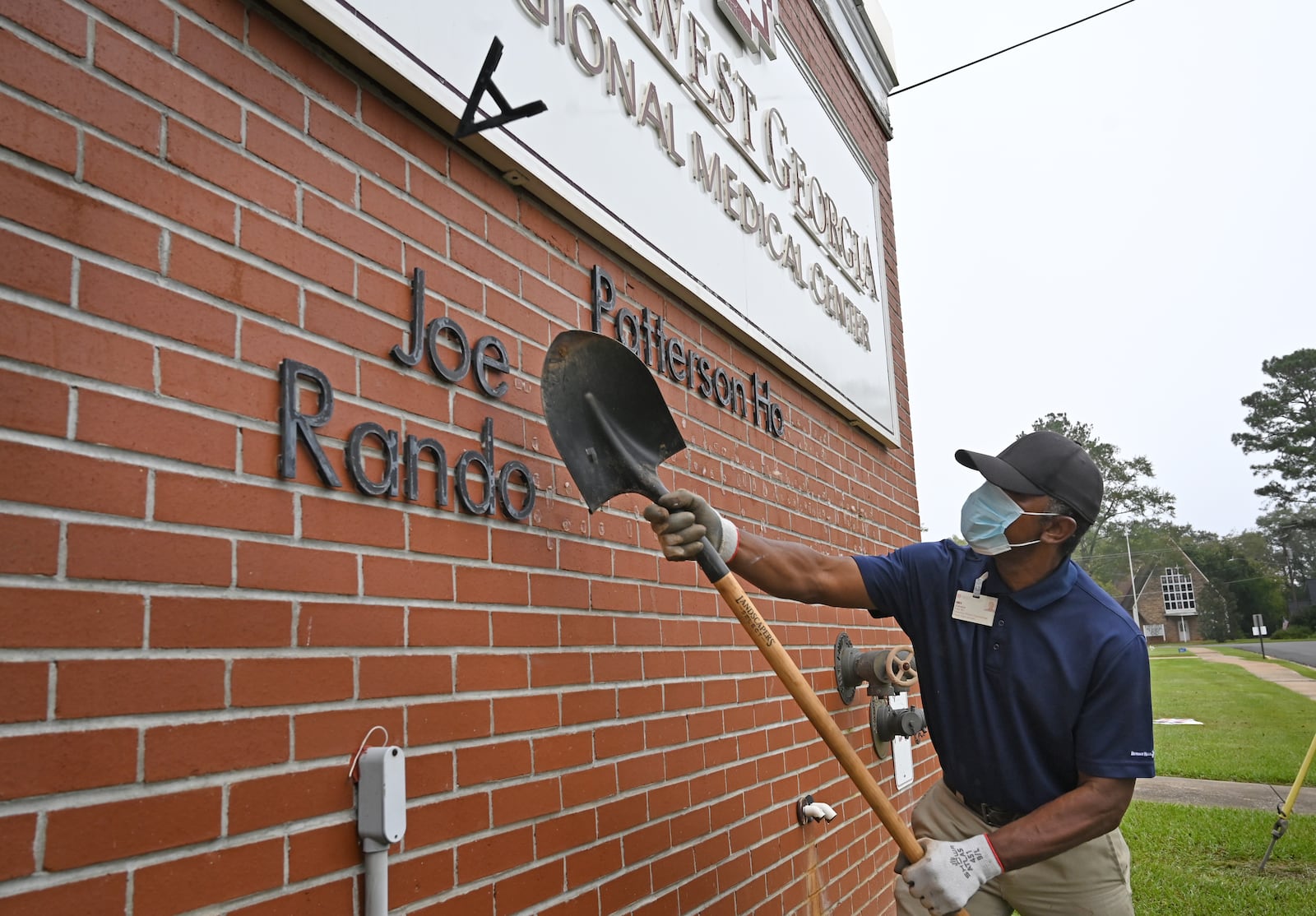 Jimmie Fair Sr., hospital maintenance staff, removes signs outside the Southwest Georgia Regional Medical Center, as the hospital closes on Thursday. (Hyosub Shin / Hyosub.Shin@ajc.com)