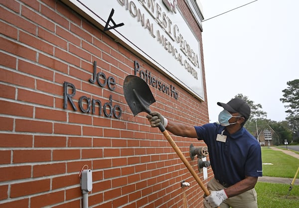 Jimmie Fair Sr., hospital maintenance staff, removes signs outside the Southwest Georgia Regional Medical Center, as the hospital closes on Thursday. (Hyosub Shin / Hyosub.Shin@ajc.com)