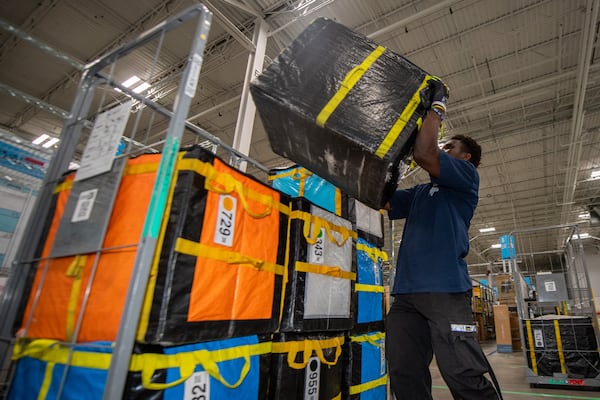 An Amazon sorting associate puts packages on a cart at an Amazon delivery station in Duluth on Tuesday, July 16, 2024.  (Ziyu Julian Zhu / AJC)