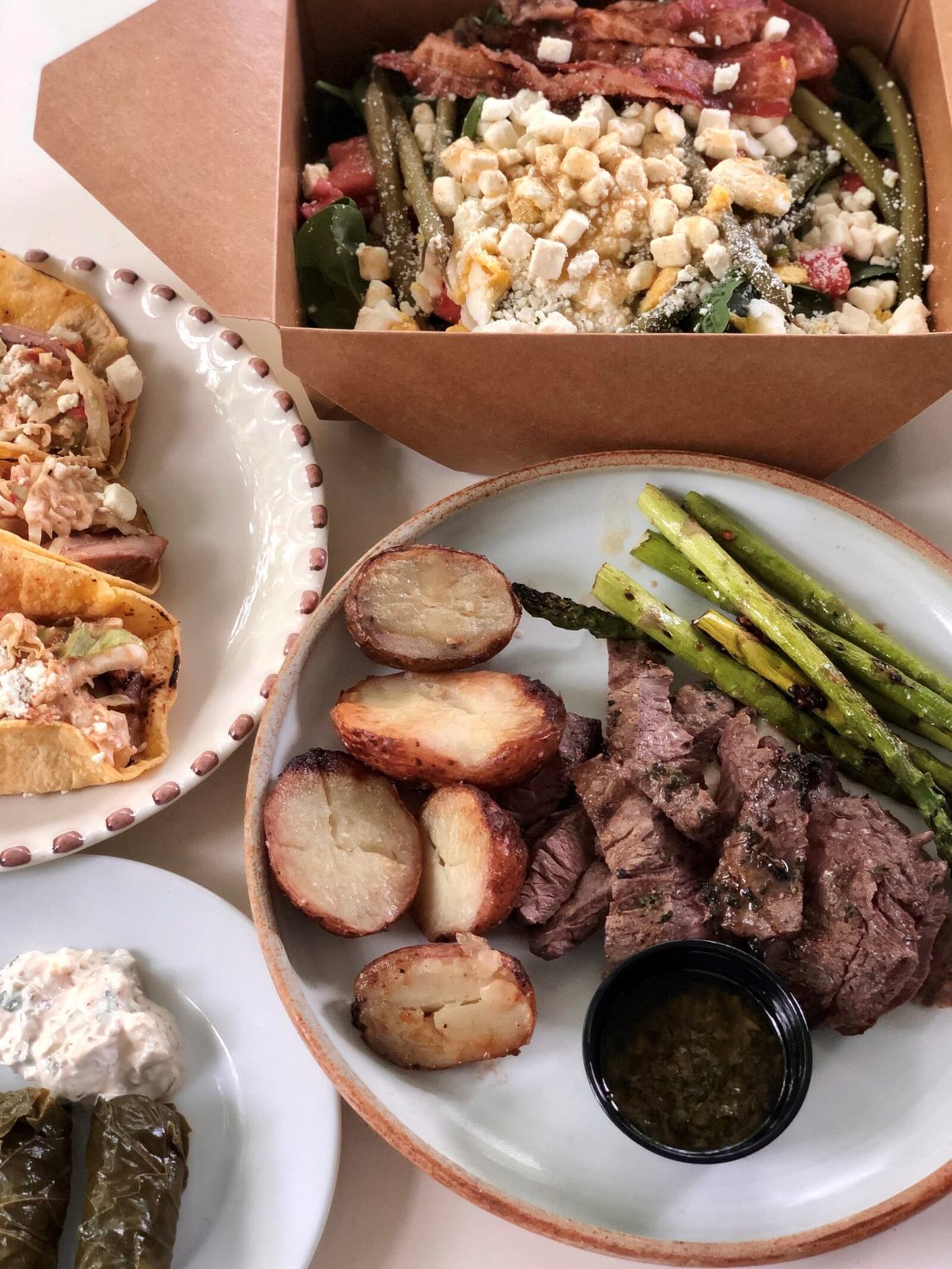 A takeout feast from Mediterranea might include a spinach salad with watermelon, steak-frites, dolmas and chicken tacos. CONTRIBUTED BY WENDELL BROCK