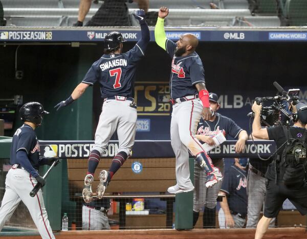 Braves shortstop Dansby Swanson (7) celebrates his solo home run with designated hitter Marcell Ozuna against the Los Angeles Dodgers during the second inning in Game 7 Sunday, Oct. 18, 2020, for the best-of-seven National League Championship Series at Globe Life Field in Arlington, Texas. (Curtis Compton / Curtis.Compton@ajc.com)



