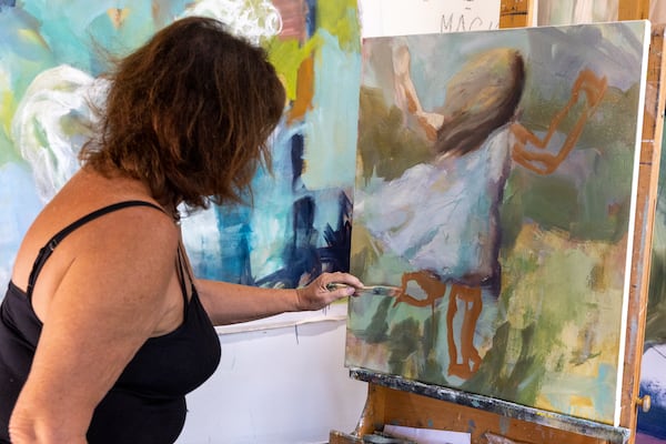 Painter Lisa Moore works in her studio in Atlanta on Friday, July 7, 2023. (Arvin Temkar / arvin.temkar@ajc.com)