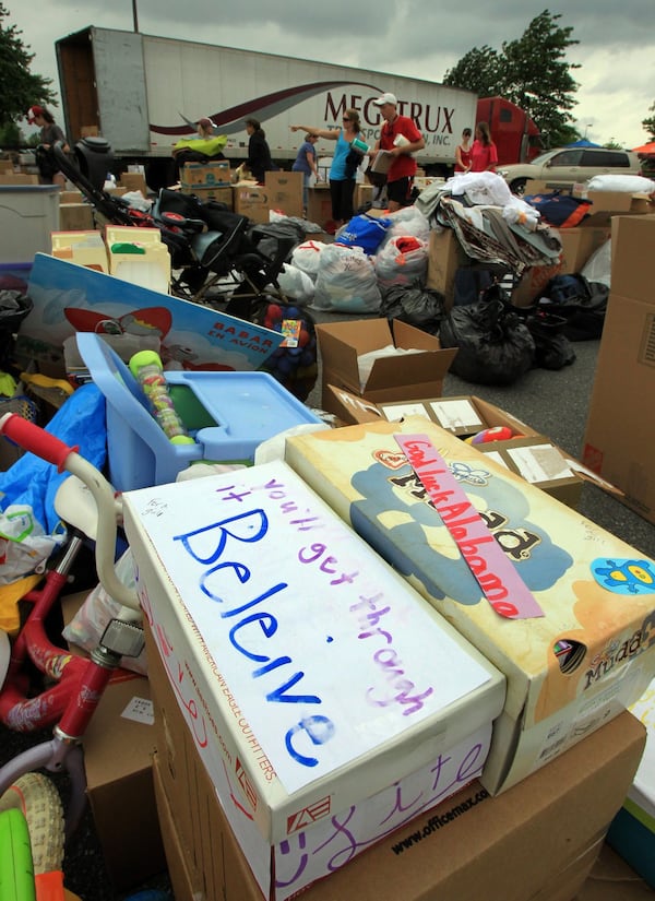 Shoeboxes containing donated goods bear messages (front) as James O’ Dwyer (upper right) leads an effort to collect and load goods on an 18-wheeler at the Home Depot in Alpharetta after a tornado hit Alabama in 2011. CURTIS COMPTON / CCOMPTON@AJC.COM