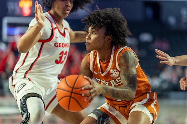 Texas guard Rori Harmon, right, looks to pass the ball against Georgia forward Mia Woolfolk (33) during the first half of an NCAA college basketball game, Monday, Feb. 24, 2025, in Athens, Ga. (AP Photo/Erik Rank)