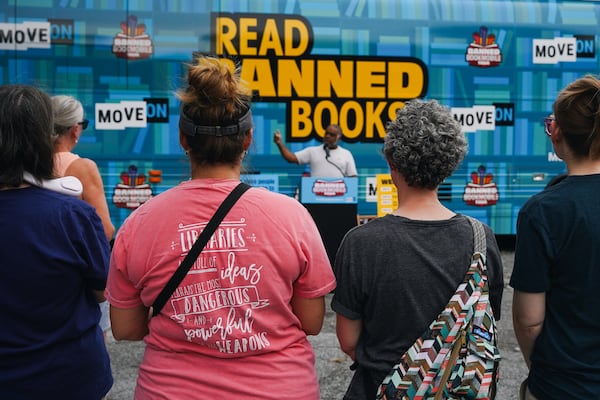 Erick Allen, former Representative and Chair of Cobb County Democrats, gives a motivational speech at one of the Banned Bookmobile Tour stops in Marietta, Georgia on Thursday, July 20, 2023. The national bus tour aims to distribute books that have been banned by Florida Governor, Ron Desantis, as an initiative to raise awareness for freedom of expression. The pink t-shirt of one of the audience members reads, "Libraries are full of ideas -- perhaps the most dangerous and powerful of all weapons." (Olivia Bowdoin for the Atlanta Journal-Constitution)