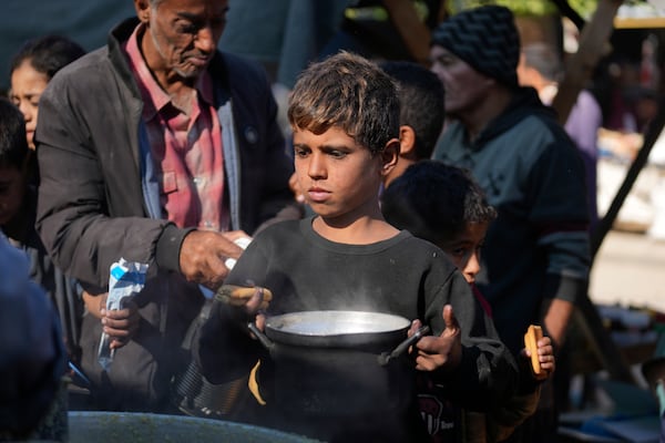 A Palestinian child queues for food in Deir al-Balah, Gaza Strip, Monday, Nov. 18, 2024. (AP Photo/Abdel Kareem Hana)