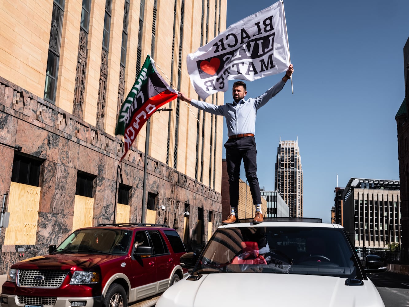 A man stands on a vehicle to show support for Black Lives Matter, in Minneapolis, Monday, March 29, 2021. (Joshua Rashaad McFadden/The New York Times)