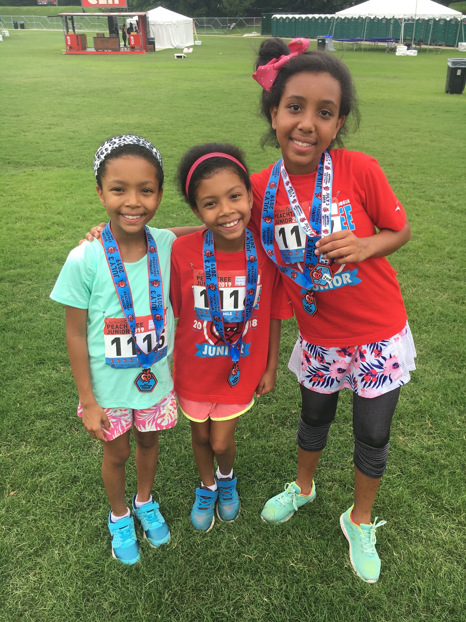 Sarah Cartner, right, age 12, poses with twin 9-year-old sisters Moriah Cartner and Bethany Cartner after they ran the Anthem Peachtree Junior on Wednesday, July 3, 2019. (Ben Brasch/AJC)