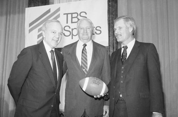 Ted Turner, right, holds a football at a news conference, Wednesday, April 11, 1985, New York. At left is Bob Wussler, Super Station WTBS president and Robert C. James, Atlantic Coast Conference commissioner, center. Turner Broadcasting System, Inc. and the Big Ten, Pacific-10 and Atlantic Coast Conferences announced a two-year agreement for live coverage of collage football games during prime-time for the 1985 and 1986 season on cables Super Station WTBS. (AP Photo/Paul Burnett)