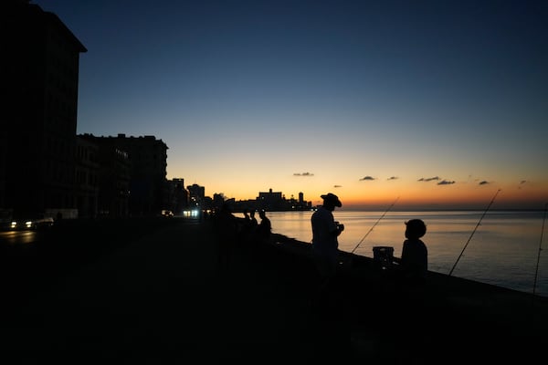 Residents spend time at sunset at the Malecon during a general blackout in Havana, Saturday, March 15, 2025. (AP Photo/Ramon Espinosa)