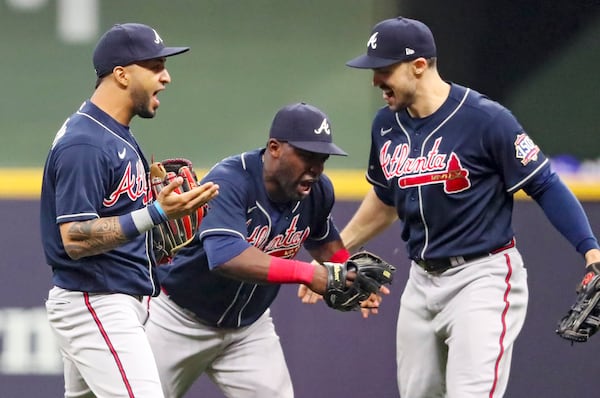 Braves left fielder Eddie Rosario (8), right fielder Jorge Soler (12) and center fielder Adam Duvall (14) celebrate the 3-0 victory.  Curtis Compton / Curtis.Compton@ajc.com 