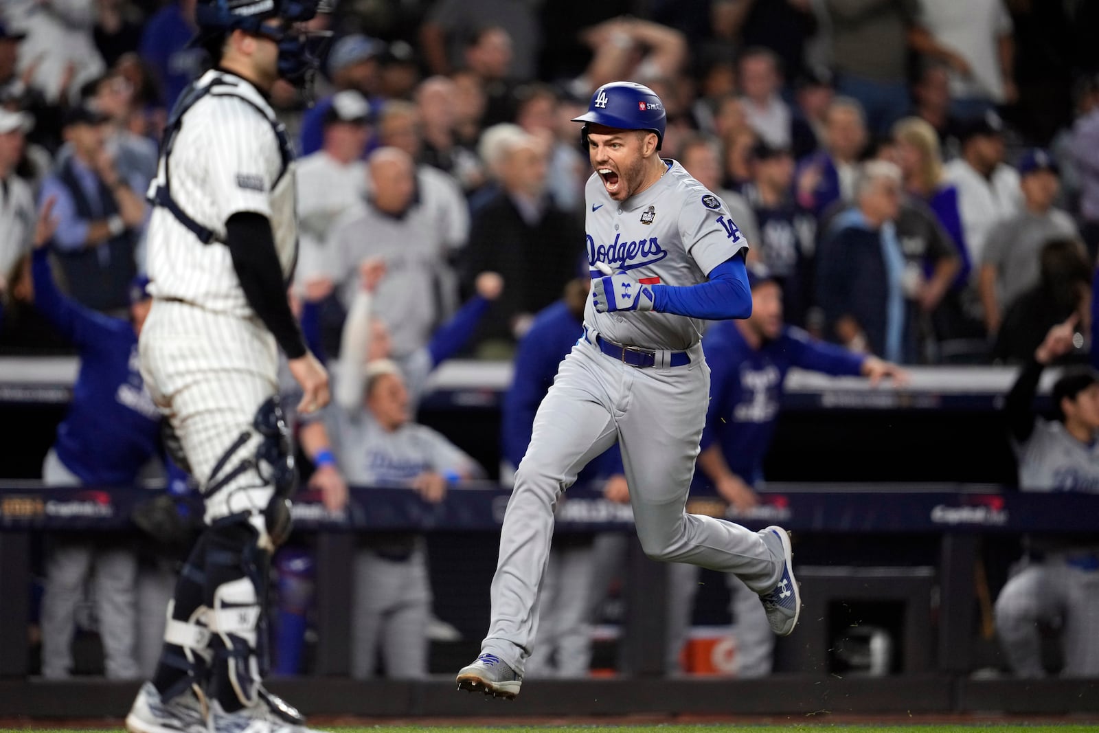 Los Angeles Dodgers' Freddie Freeman, right, runs toward home plate to score against the New York Yankees during the fifth inning in Game 5 of the baseball World Series, Wednesday, Oct. 30, 2024, in New York. (AP Photo/Godofredo A. Vásquez)