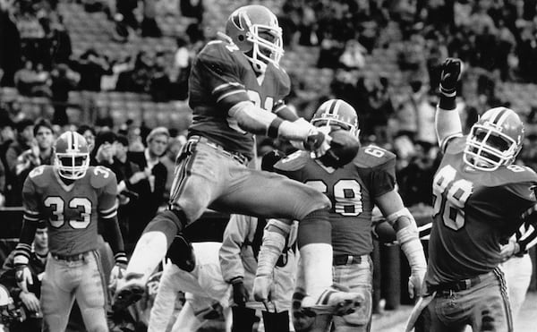 William Andrews prepares to spike the ball over his back after scoring a touchdown.