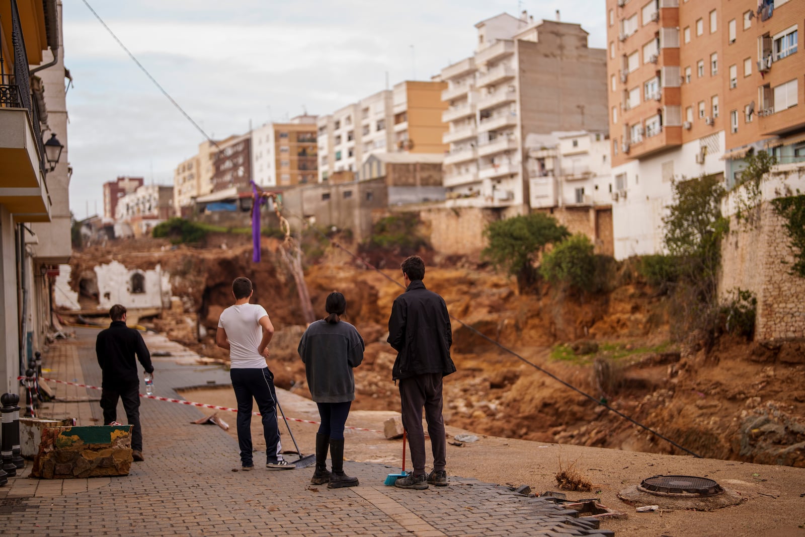 People stand in an area affected by floods in Chiva, Spain, Friday, Nov. 1, 2024. (AP Photo/Manu Fernandez)