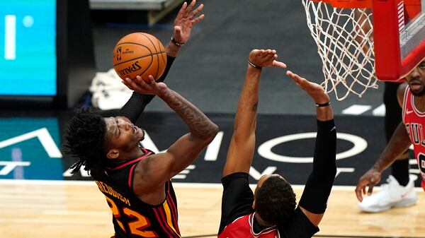 Hawks' Cam Reddish (left) shoots against the Bulls' Daniel Gafford during the second half of the season opener Wednesday, Dec. 23, 2020, in Chicago. (Nam Y. Huh/AP)