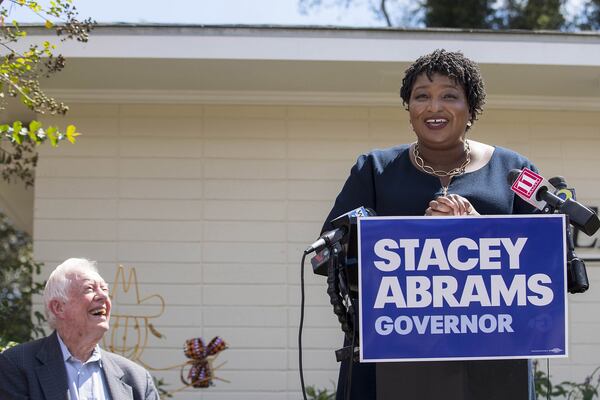 Former President Jimmy Carter listens as Georgia Gubernatorial Democratic candidate Stacey Abrams speaks during a campaign stop at Mercer Medicine at Plains health clinic in September. Abrams has made expansion of Medicaid one of her top priorities.