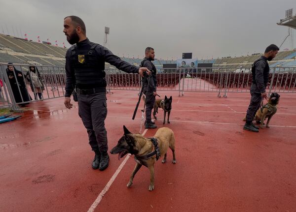 Hezbollah security members with their dogs stand in Beirut's City Sportive stadium, a day ahead of the funeral procession of the two late Hezbollah leaders Sayyed Hassan Nasrallah and Sayyed Hashem Safieddine, in Beirut, Lebanon, Saturday, Feb. 22, 2025. (AP Photo/Hussein Malla)