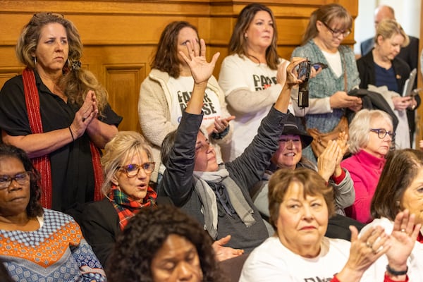 Paper ballot supporters applaud a public speaker at a State Election Board meeting at the Capitol in Atlanta on Tuesday, December 19, 2023. (Arvin Temkar / arvin.temkar@ajc.com)