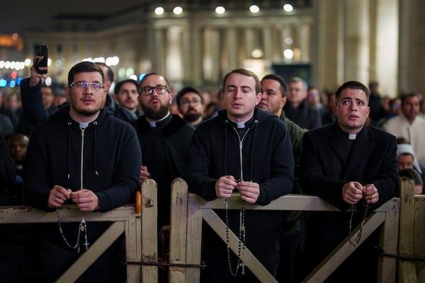 Catholic priests pray the rosary in St. Peter's Square at The Vatican for the recovery of Pope Francis, Monday, Feb. 24, 2025. (AP Photo/Bernat Armangue)