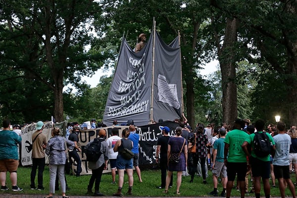 Banners were used to cover the dismantling of the Silent Sam statue when people gathered during a rally in August 2018.