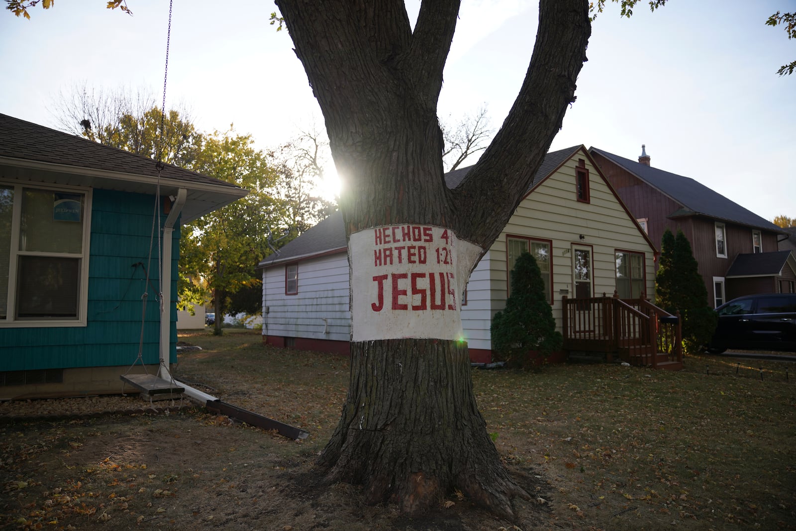 A religious sign is carved into a tree in a neighborhood of Worthington, Minn., on Monday, Oct. 21, 2024. (AP Photo/Jessie Wardarski)