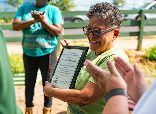 Historic Westside Gardens founder Rosario Hernandez reacts to receiving the EPA’s National Notable Achievement Award at a community garden run by Historic Westside Gardens in Atlanta on Wednesday, August 14, 2024. (Seeger Gray / AJC)