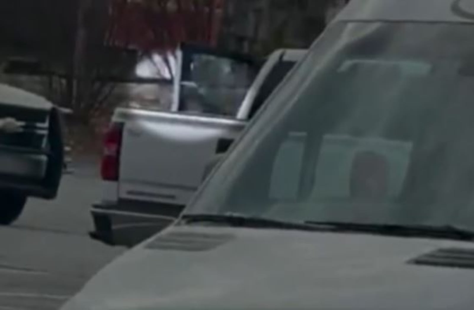 A still image from video at the scene in Ellenwood shows what appears to be a gun extending from the door of Arrett Carr's white pickup truck moments before he was shot.