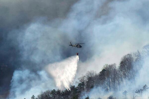 In this March 23, 2025, photo released by the U.S. National Guard shows a UH-60 Black Hawk helicopter from the 1-111th General Support Aviation Battalion, 59th Aviation Troop Command, McEntire Joint National Guard Base in Eastover executing its fire suppression mission in support of the South Carolina Forestry Commission at Persimmon Ridge Fire near Greenville, S.C. (Sgt. 1st Class Roberto Di Giovine/U.S. Army National Guard via AP)