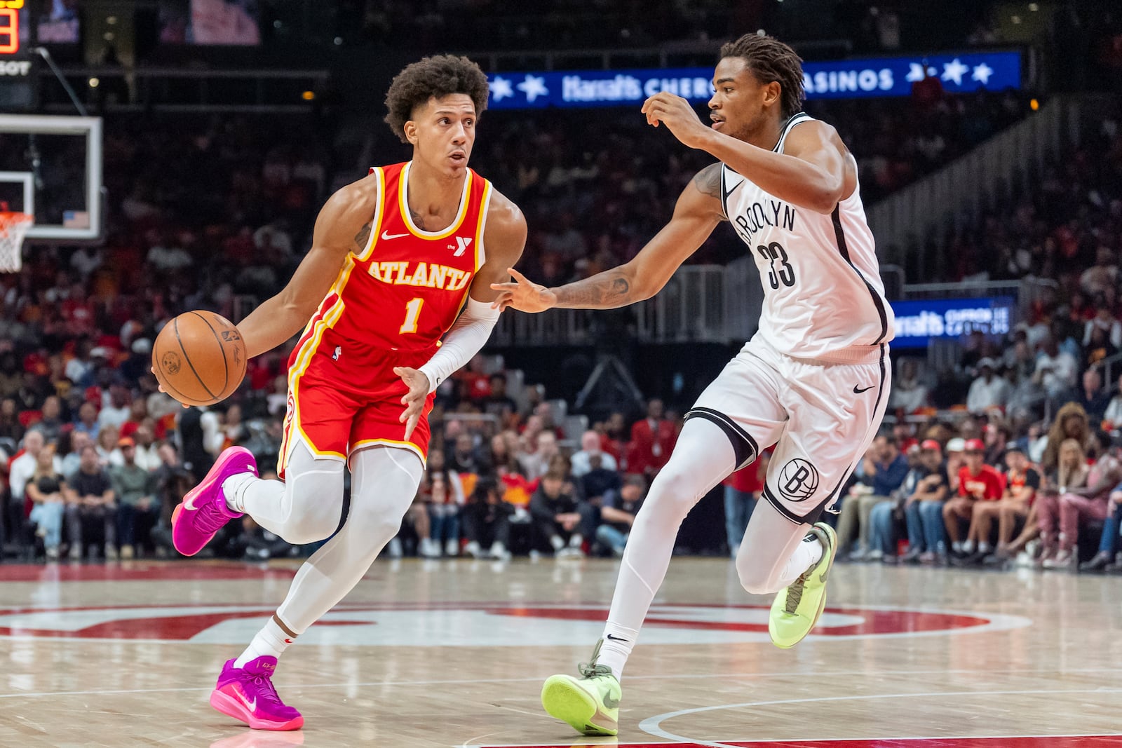 Atlanta Hawks forward Jalen Johnson (1) drives the lane guarded by Brooklyn Nets center Nic Claxton (33) during the first half of an NBA basketball game, Wednesday, Oct. 23, 2024, in Atlanta. (AP Photo/Jason Allen)