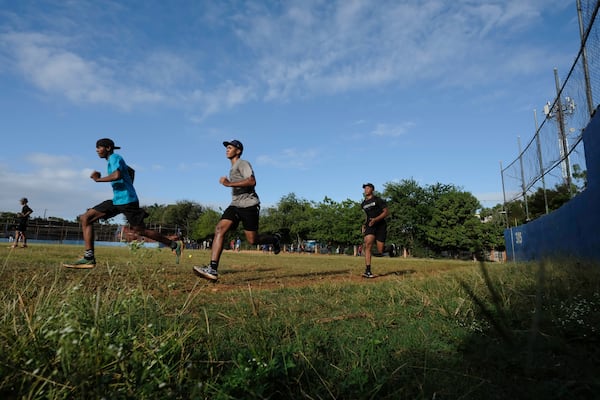 Teenage baseball players run laps during their daily training session at the Trinitarios ballpark in Santo Domingo, Dominican Republic, Wednesday, Feb. 5, 2025. (AP Photo/Ricardo Hernandez)