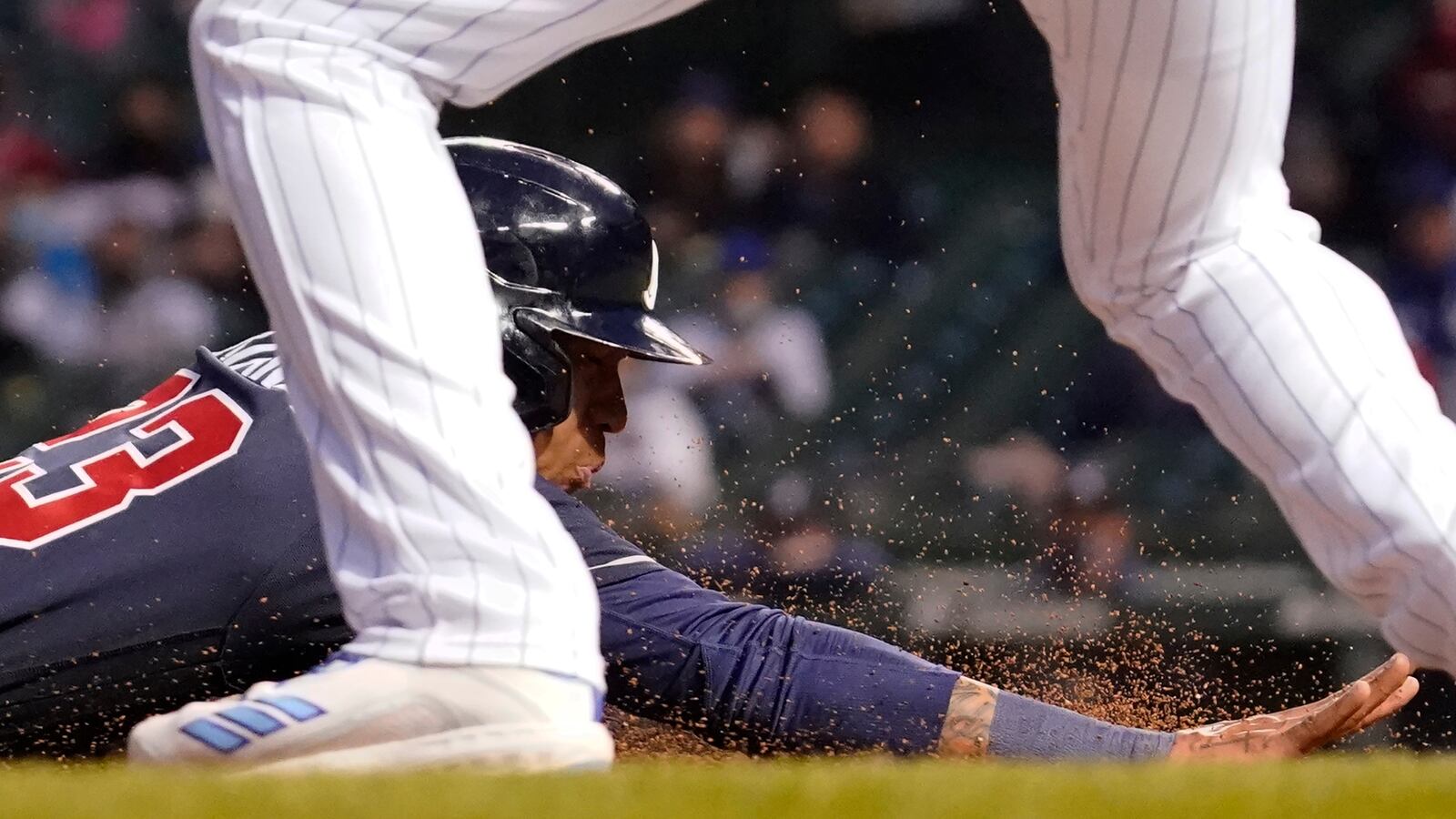 Braves' Ehire Adrianza slides into third base against Chicago Cubs third baseman Kris Bryant after Austin Riley hit a single during the fifth inning Sunday, April 18, 2021, at Wrigley Field in Chicago. (Nam Y. Huh/AP)