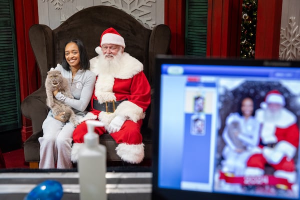 Tamian Hill and her cat Ellie take pictures with Santa at Perimeter Mall in Dunwoody on Monday, November 18, 2024. (Arvin Temkar / AJC)