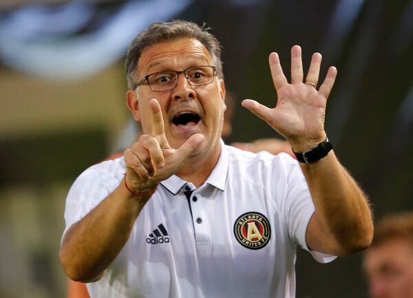 Atlanta United head coach Gerardo "Tata" Martino signals to his players in the second half of an MLS soccer match against the Columbus Crew Saturday, June 17, 2017, in Atlanta (AP Photo/John Bazemore)