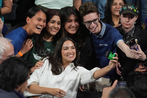 Rep. Alexandria Ocasio-Cortez, D-N.Y., right, takes a photo with supporters after speaking during a "Fighting Oligarchy" tour event at Arizona State University, Thursday, March 20, 2025, in Tempe, Ariz. (AP Photo/Ross D. Franklin)