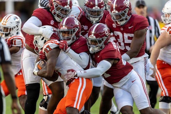 Alabama linebacker Justin Okoronkwo (41), defensive back Dre Kirkpatrick Jr. (21) and others gang-tackle Mercer running back Micah Bell (27), during the second half of an NCAA college football game, Saturday, Nov. 16, 2024, in Tuscaloosa, Ala. (AP Photo/Vasha Hunt)