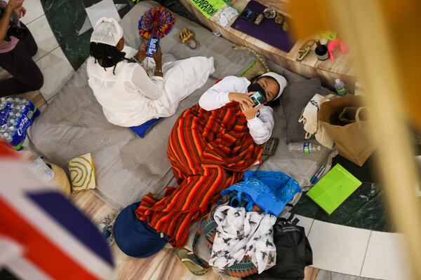 A protestor lays on the floor of the atrium of Atlanta City Hall during the public comment portion ahead of the final vote to approve legislation to fund the training center, on Monday, June 5, 2023, in Atlanta. (Jason Getz / Jason.Getz@ajc.com)