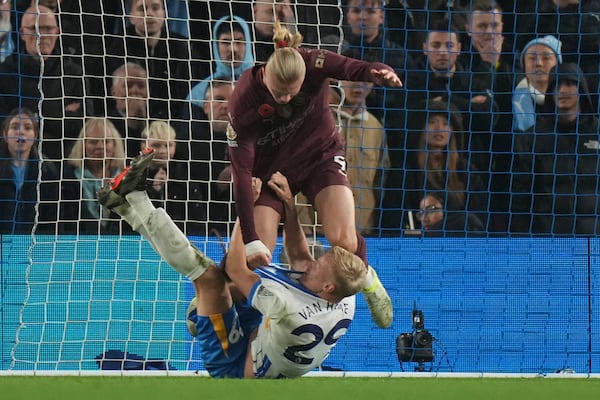 Manchester City's Erling Haaland grabs Brighton's Jan Paul van Hecke during the English Premier League soccer match between Brighton and Manchester City at Falmer Stadium in Brighton, England, Saturday, Nov. 9, 2024. (AP Photo/Alastair Grant)