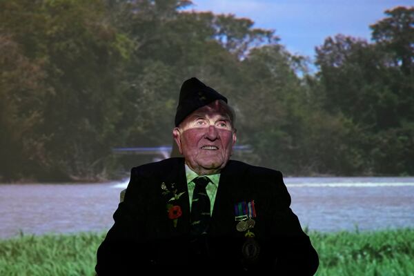 Michael Woods, 100-year-old World War II veteran, sits in front of a projecting image during an interview in Dunstable, Bedfordshire, England, Tuesday, Nov. 5, 2024. (AP Photo/Kin Cheung)