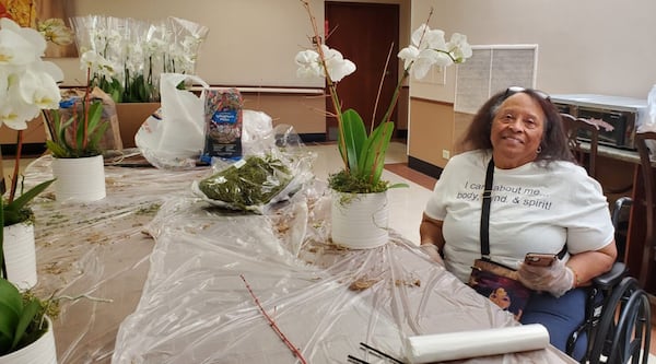 Evette Oates helps prepare orchid centerpieces for a luncheon as part of a horticultural therapy session during a Generation Connect summer service camp at A.G. Rhodes.