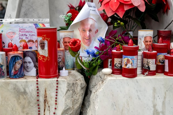 Flowers and candles are placed at the base of the statue of Pope John Paul II outside Gemelli Hospital in Rome, where Pope Francis is being treated for pneumonia, a complex infection and kidney problems that have left him in critical condition, on Monday, Feb. 24, 2025. While Francis’ fate is still unclear, what is more certain are the time-honored rituals that were drafted and refined over the centuries to ensure secrecy and an orderly transition. (James Hill/The New York Times)
                      