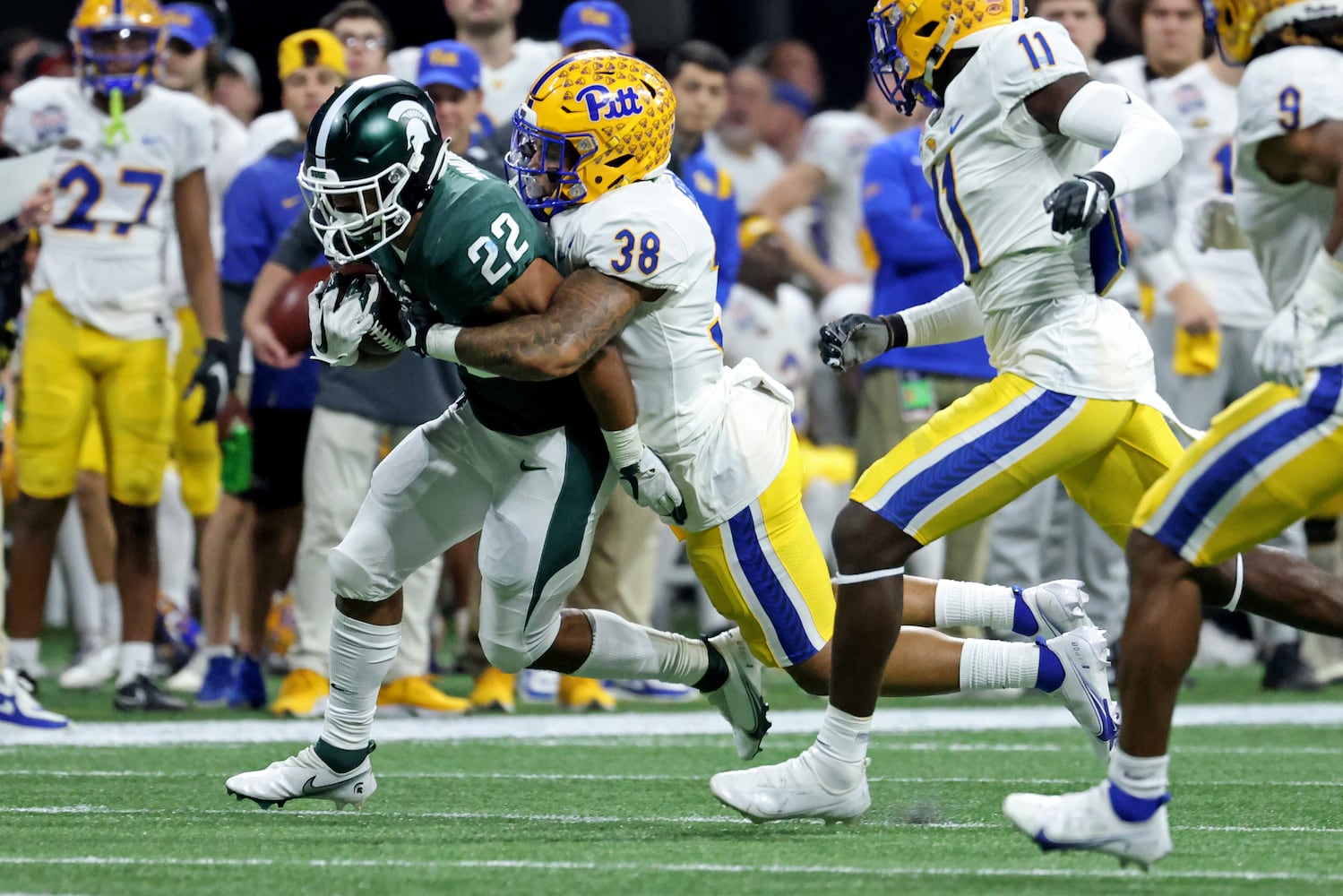 Michigan State Spartans running back Jordon Simmons (22) runs against Pittsburgh Panthers linebacker Cam Bright (38) during the first half of the Chick-fil-A Peach Bowl at Mercedes-Benz Stadium in Atlanta, Thursday, December 30, 2021. Simmons is a graduate of McEachern high school. JASON GETZ FOR THE ATLANTA JOURNAL-CONSTITUTION