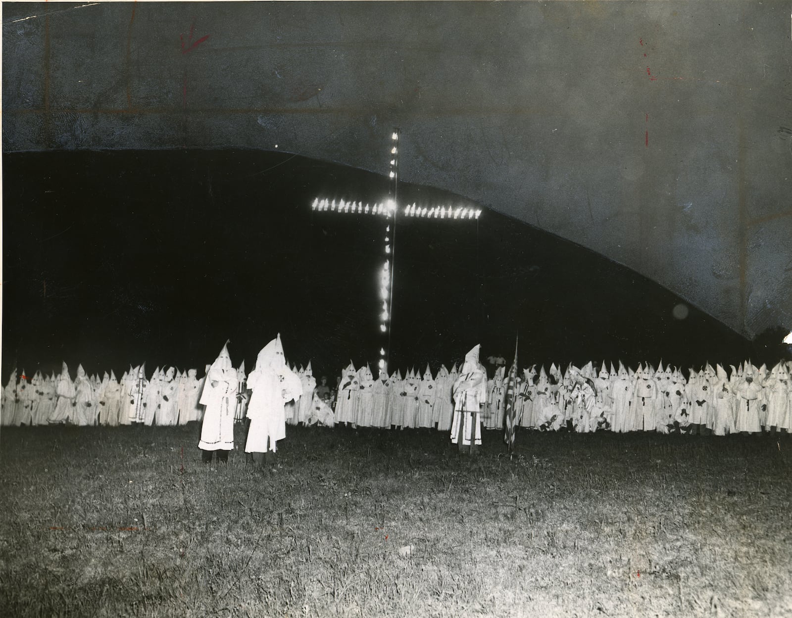 B/W copy photo taken in 1948: Hooded Ku Klux Klansmen gather around a huge flaming cross as the Klan held one of its largest initiation ceremonies in its life. In the background looms Stone Mountain. (ACME TELEPHOTO/AJC FILES). For Metro.