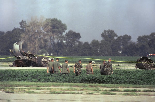 FILE - In this July 20, 1989 file photo Iowa Air National Guard soldiers search a field near the burned engine of United Airlines Flight 232 after the McDonnell Douglas DC-10 carrying nearly 300 people crash landed at the Sioux City, Iowa, airport. (AP Photo/James Finley, File)