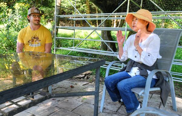 Megan Cai (right), co-owner of Ellijay Mushrooms, talks about the beginnings of the farm, the history of the property and some of the future projects for the land and buildings. Co-owner Howard Berk is with her. (Chris Hunt for The Atlanta Journal-Constitution)