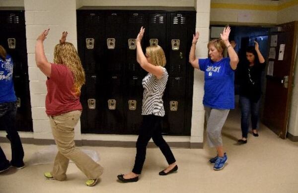 Teachers portray students during a school-shooting training exercise with police in 2015. Police won’t be the only ones legally armed in some Georgia school systems in coming years. Two school systems have approved arming teachers, and more are considering it. (AJC 2015)