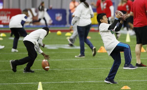 About 300 mostly Hispanic children take part in passing drills at the Play 60 Character Camp during Super Bowl Week. The event, in partnership with Pro Football Hall of Fame offensive tackle Anthony Muñoz, focuses on the importance of wellness and character. 