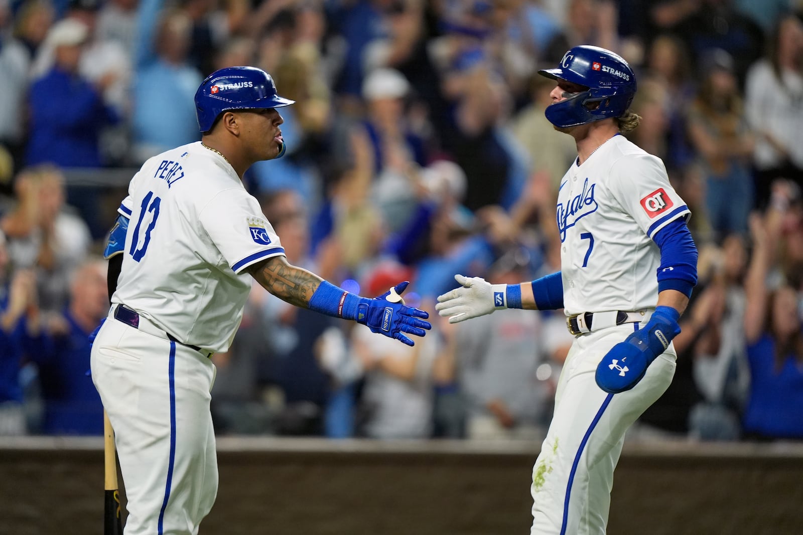 Kansas City Royals' Bobby Witt Jr. (7) is congratulated by teammate Salvador Perez (13) after scoring during the sixth inning in Game 4 of an American League Division baseball playoff series against the New York Yankees Thursday, Oct. 10, 2024, in Kansas City, Mo. (AP Photo/Charlie Riedel)